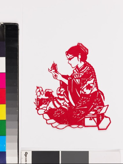 Girl in national minority costume kneeling by two lambsfront