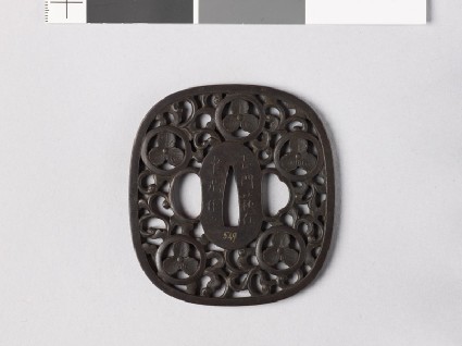 Tsuba with heraldic device and karakusa, or scrolling plant patternfront